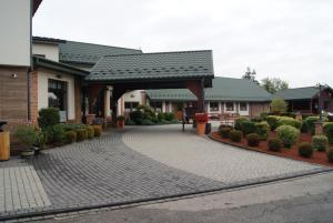 a house with a brick driveway in front of a building at Pokoje w Moszczenicy U Pasonia in Stary Sącz