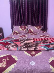 Una cama con un edredón con pechos. en Hotel PNR'S Paradise en Ooty