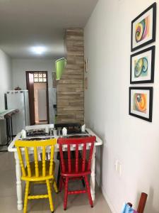 eine Küche mit 2 Stühlen und einem Tisch mit einem Herd in der Unterkunft A casa da Keila - Balneário Camboriú in Balneário Camboriú