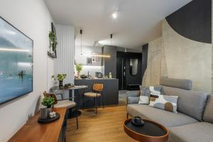 - un salon avec un canapé et une table dans l'établissement Emihouse Riverside Apartments, à Rzeszów