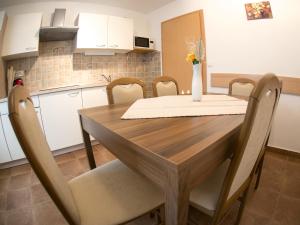 a dining room table with chairs and a vase of flowers on it at Apartments Demec in Kranjska Gora