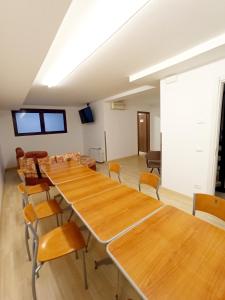 una sala de conferencias con mesas y sillas de madera en IL LOFT AI PILA, en Montebelluna