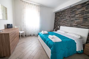 una camera con un grande letto e un muro di mattoni di U ventu che tira casa centro storico vicino porto wi fi a Trapani