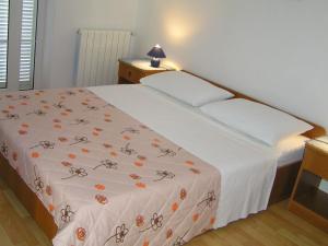 a bedroom with a bed with a white bedspread with flowers on it at Apartments Paloma blanca 1 in Medulin
