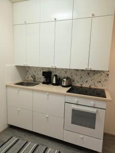 eine weiße Küche mit weißen Schränken und einem Waschbecken in der Unterkunft Viettola in Pielavesi