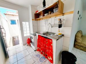 Il comprend une petite cuisine équipée d'un évier et d'une cuisinière. dans l'établissement Kitnet Quarto Sala Cozinha com Ar Condicionado 102, à Cabo Frio