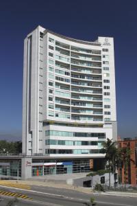Un grand bâtiment blanc avec de nombreuses fenêtres dans l'établissement Estelar Apartamentos Medellin, à Medellín