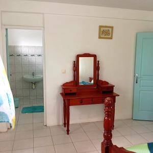 a bathroom with a table with a mirror on it at Villa léïna, vacances en famille écotourisme in Le Robert