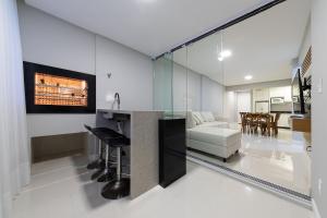 Il comprend une cuisine et un salon avec un mur en verre. dans l'établissement Apto aconchegante a 450m do mar EAN503, à Balneário Camboriú