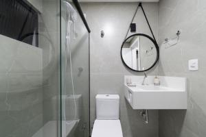 La salle de bains est pourvue de toilettes, d'un lavabo et d'un miroir. dans l'établissement Apto aconchegante a 450m do mar EAN503, à Balneário Camboriú