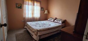 a small bedroom with a bed and a window at Vista Stays ...Alluring Ambrosia near to Airport in Trincity 