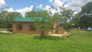 a small house with a tree in the yard at Two Bed Two Bath Cottage in Bulawayo