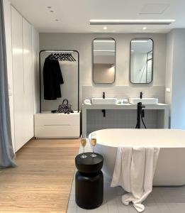 a bathroom with a tub and two sinks and mirrors at AIONION RESIDENCES by K&K in Athens