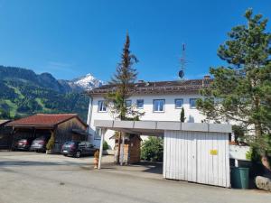 a white house with a garage in front of it at Haus Kreuzeckwiese - Fewo Jübilaumsgrat in Garmisch-Partenkirchen