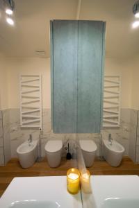 uma casa de banho com 3 lavatórios e um espelho grande em tHE Urban Wildlife - San Babila Home em Milão