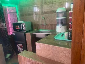 uma cozinha com um balcão com um lavatório e comodidades para preparar café em La fierté em Ziguinchor
