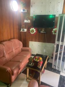 a living room with a leather couch and a tv at La fierté in Ziguinchor