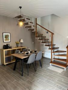 a dining room with a table and a spiral staircase at Easy Living 1 & 2 in Kos Town