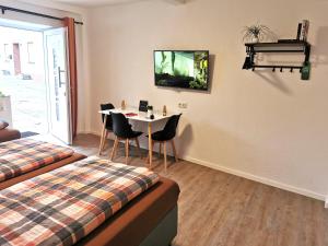 Cette chambre comprend un lit, une table et des chaises. dans l'établissement Speedys Bed & Breakfast, à Reimerath