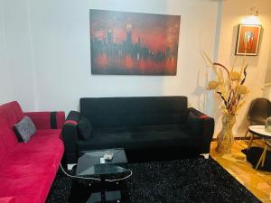 a living room with a red couch and a painting at Studio à quelques mètres d ponts, monument d morts in Constantine
