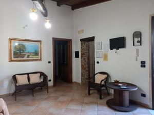 un soggiorno con tavolo, sedie e TV di Curti Russi a Monteroni di Lecce