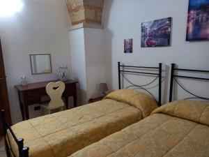 蒙泰羅尼迪萊切的住宿－Curti Russi，一间卧室配有两张床、一张桌子和一把椅子