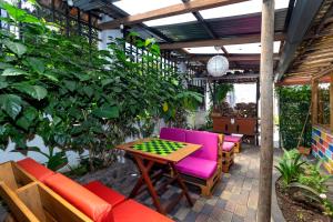 a patio with colorful chairs and a table and chessboard at Santa Cruz Backpackers Hostal in Baños