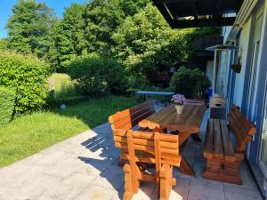 a wooden table and benches sitting outside of a house at Haus Kreuzeckwiese - Fewo Jübilaumsgrat in Garmisch-Partenkirchen