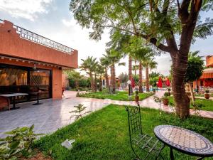 a park with a bench and a table and a tree at Villa Gardens Diafa in Marrakesh