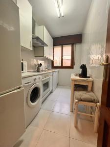 a kitchen with a washing machine and a table at Apartamento en la costa in Lekeitio