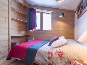 a bedroom with a bed in a room with wooden walls at Appartement Les Arcs 1800, 4 pièces, 8 personnes - FR-1-346-321 in Arc 1800
