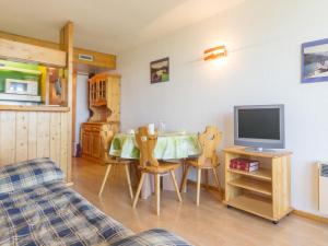 a living room with a table with chairs and a television at Studio Les Arcs 1800, 1 pièce, 5 personnes - FR-1-346-422 in Arc 1800