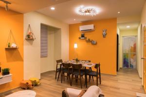 una sala da pranzo con pareti arancioni, tavolo e sedie di Orange Tatami Funny House at Bukit Beruang Malacca a Malacca