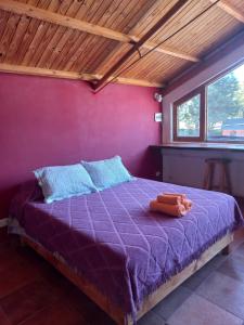 sypialnia z fioletowym łóżkiem z pluszakiem w obiekcie Depa centro comercial w mieście Villa Pehuenia