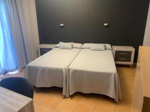 - une chambre avec un grand lit blanc et 2 oreillers dans l'établissement Cal Mariner, à El Port de la Selva