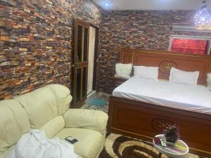 a bedroom with a bed and a couch and a chair at La fierté in Ziguinchor