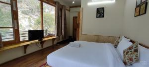 Tirthan Grand Riverside客房内的一张或多张床位