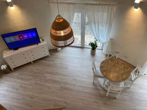 uma sala de estar com uma mesa e uma televisão em Kupolinis namelis 