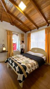 1 dormitorio con 1 cama grande frente a una ventana en Santa Cruz Backpackers Hostal, en Baños