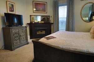 1 dormitorio con cama, TV y espejo en Cloran Mansion Bed & Breakfast en Galena