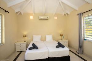 a bedroom with a large white bed with two night stands at Penthouse Prikichi D2 in Kralendijk +35 photos