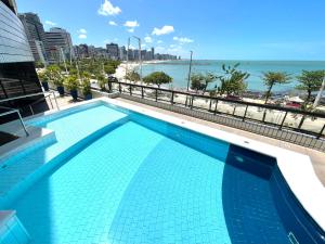 a swimming pool with a view of the beach at Aconchego à Beira Mar (no melhor do Meireles) in Fortaleza