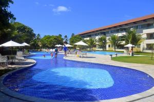 duży błękitny basen z chodzącymi ludźmi w obiekcie Lindo Flat Praia dos Carneiros - Carneiros Beach Resort w mieście Praia dos Carneiros