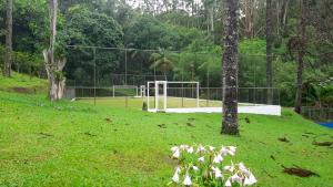 a field with a volley ball hoop in a park at Casa de campo agradável com piscina, parquinho, lago, riacho, quadra, sinuca e mais! in Juquitiba