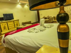 een slaapkamer met een bed met een tafel en een lamp bij Purity Pyramids View Palace in Caïro