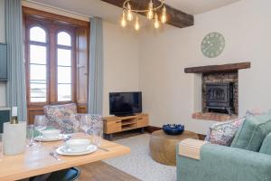 a living room with a table and a couch and a television at Watermouth Castle, West Tower Apartment in Ilfracombe