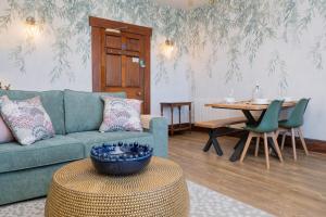a living room with a green couch and a table at Watermouth Castle, West Tower Apartment in Ilfracombe