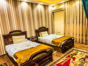 een slaapkamer met 2 bedden en een tapijt bij Purity Pyramids View Palace in Caïro