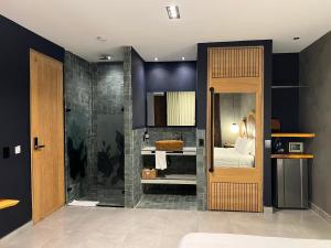 a bathroom with a shower with a bed and a mirror at Hotel Poblado Park in Medellín