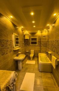 een badkamer met een wastafel, een bad en een toilet bij Purity Pyramids View Palace in Caïro